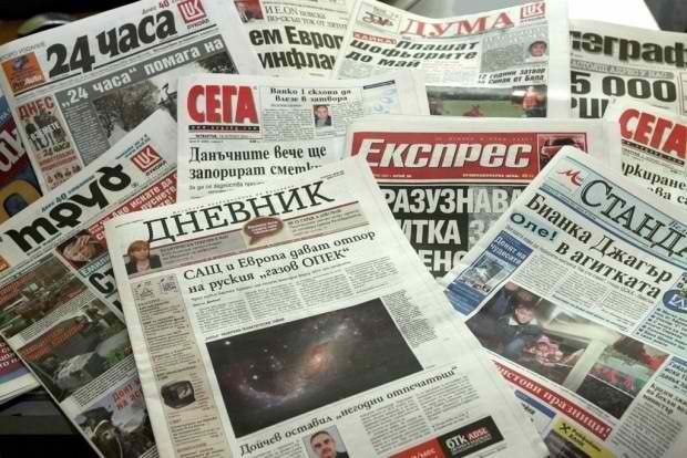 Collection of various Bulgarian newspapers spread out on a flat surface, showing different headlines and images.